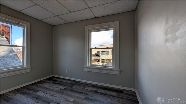 1105 Pursell Ave, Dayton, OH 45420 - spare room featuring dark wood-style flooring, plenty of natural light, and a paneled ceiling