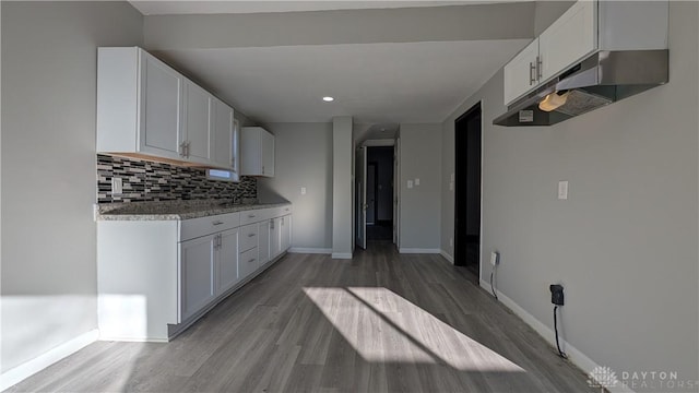 1105 Pursell Ave, Dayton, OH 45420 - kitchen with light wood-type flooring, decorative backsplash, white cabinets, under cabinet range hood, and recessed lighting