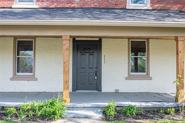 117 Montgomery Ave, Franklin, OH 45005 - view of exterior entry with a porch, roof with shingles, and brick siding