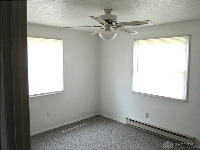 unfurnished room featuring baseboard heating, a textured ceiling, a ceiling fan, and a healthy amount of sunlight