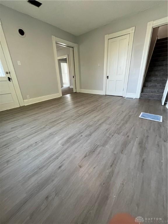 400 S Detroit St, Xenia, OH 45385 - unfurnished living room with baseboards, wood finished floors, and stairway