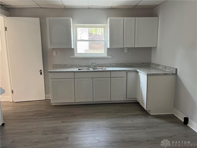400 S Detroit St, Xenia, OH 45385 - kitchen featuring a drop ceiling, a sink, baseboards, wood finished floors, and light countertops
