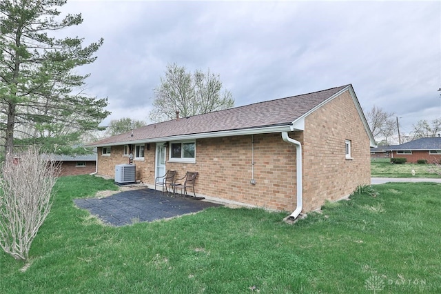 320 Orangewood Dr, Dayton, OH 45429 - rear view of house featuring a patio area, a lawn, brick siding, and cooling unit