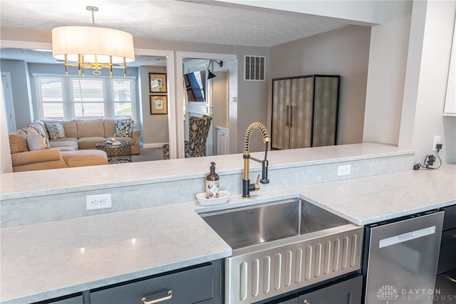 kitchen with a sink, visible vents, light stone counters, gray cabinets, and dishwasher