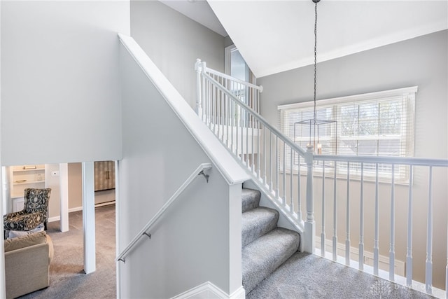 staircase featuring vaulted ceiling, baseboards, carpet floors, and a chandelier