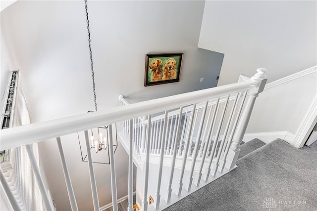 stairway featuring carpet and a notable chandelier