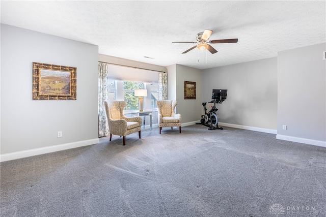 living area with carpet, a textured ceiling, a ceiling fan, and baseboards