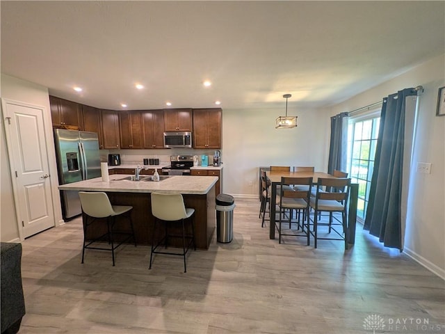 2408 Valleybrook Ct, Batavia, OH 45103 - kitchen with dark brown cabinets, a sink, a kitchen bar, and appliances with stainless steel finishes