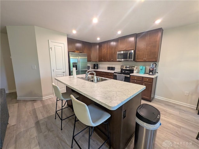 2408 Valleybrook Ct, Batavia, OH 45103 - kitchen with a sink, baseboards, appliances with stainless steel finishes, light countertops, and a breakfast bar area