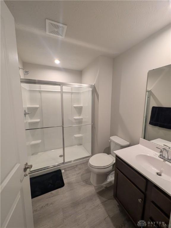 2408 Valleybrook Ct, Batavia, OH 45103 - full bath with a shower stall, wood finished floors, visible vents, toilet, and vanity