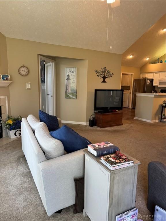 9632 Belfry Ct, Dayton, OH 45458 - living room featuring lofted ceiling, a textured ceiling, and light colored carpet