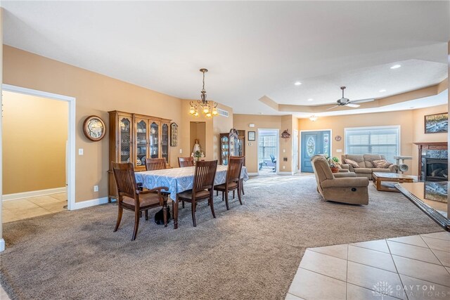 dining space featuring a high end fireplace, tile patterned flooring, and carpet