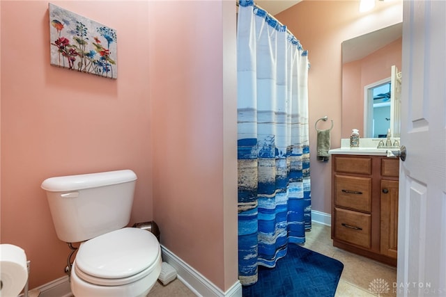 bathroom featuring toilet, baseboards, curtained shower, and vanity