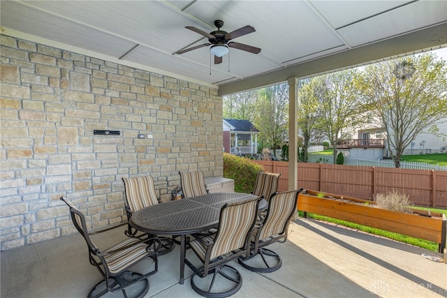 view of patio with fence, outdoor dining area, and ceiling fan