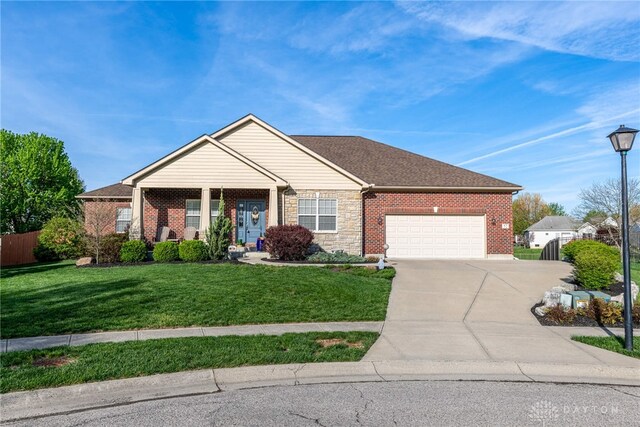 view of front facade with driveway, brick siding, fence, a front lawn, and an attached garage
