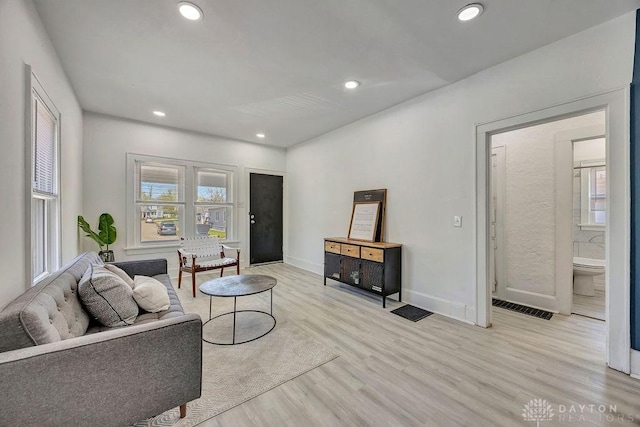 living area featuring recessed lighting, light wood-style floors, visible vents, and baseboards