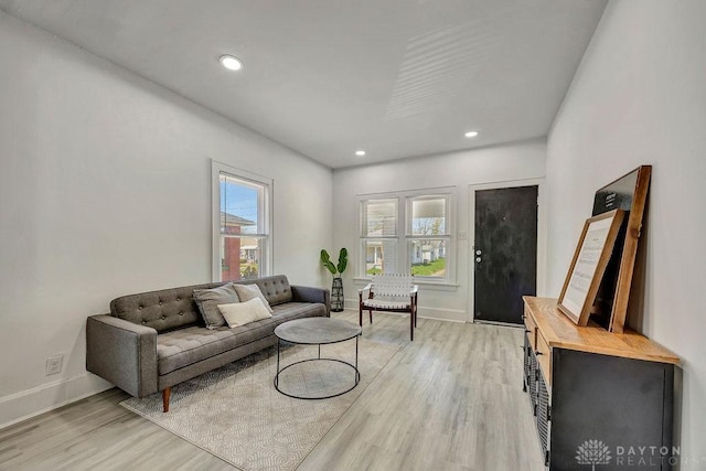 living area with recessed lighting, baseboards, and light wood-style flooring