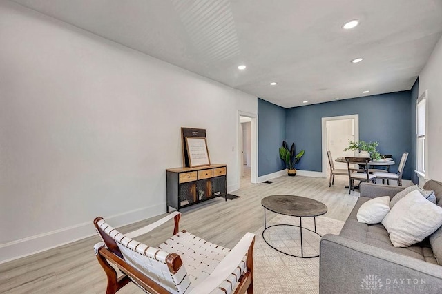 living area featuring light wood finished floors, baseboards, and recessed lighting