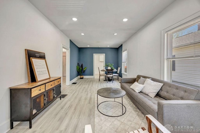 living area featuring light wood-style flooring, baseboards, and recessed lighting