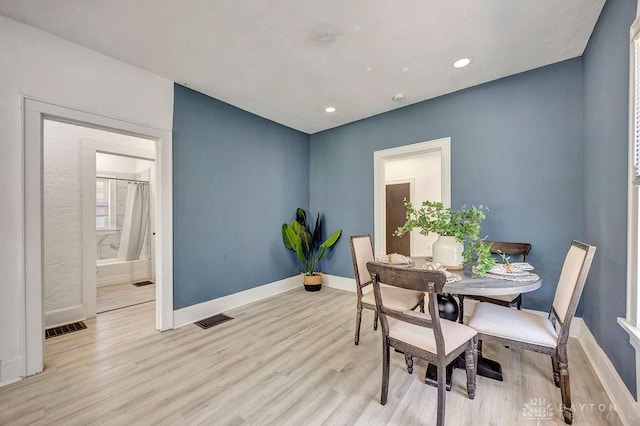 dining area with wood finished floors, visible vents, and baseboards