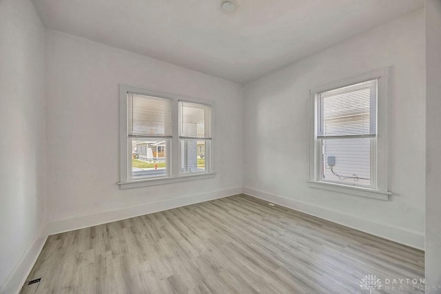 unfurnished room with baseboards and light wood-style floors