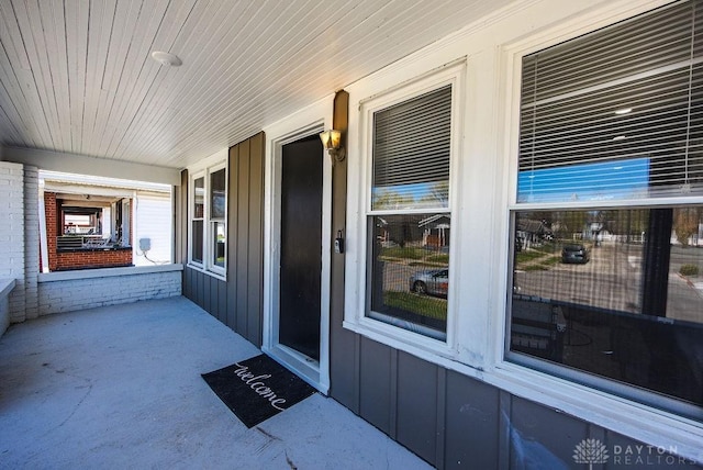 property entrance with board and batten siding and covered porch