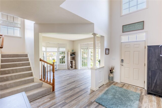 3513 Black Squirrel Way, Springboro, OH 45005 - foyer entrance with decorative columns, light wood-type flooring, stairs, baseboards, and a towering ceiling