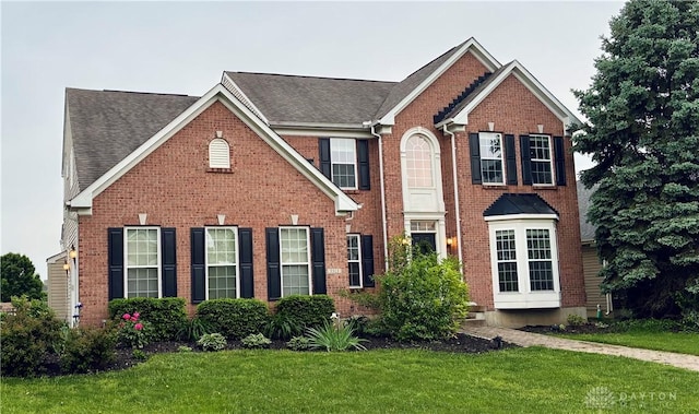 3513 Black Squirrel Way, Springboro, OH 45005 - view of front of house with a front yard, brick siding, and a shingled roof