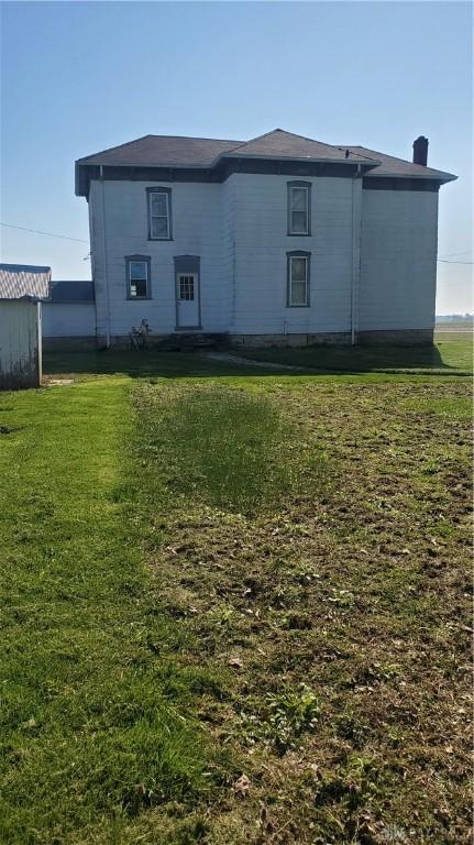 back of property with a lawn