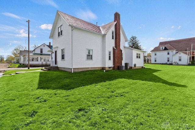 203 W Plum St, Saint Paris, OH 43072 - rear view of house featuring a chimney, a yard, and central AC unit