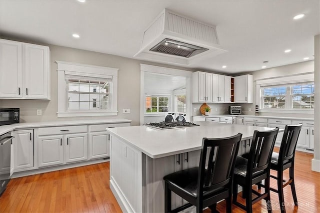 203 W Plum St, Saint Paris, OH 43072 - kitchen featuring appliances with stainless steel finishes, healthy amount of natural light, custom exhaust hood, a kitchen bar, and recessed lighting