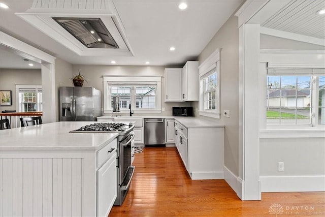 203 W Plum St, Saint Paris, OH 43072 - kitchen featuring stainless steel appliances, light countertops, light wood-style flooring, white cabinetry, and recessed lighting