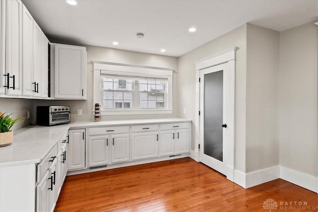 203 W Plum St, Saint Paris, OH 43072 - kitchen with light wood-type flooring, white cabinets, light countertops, recessed lighting, and baseboards