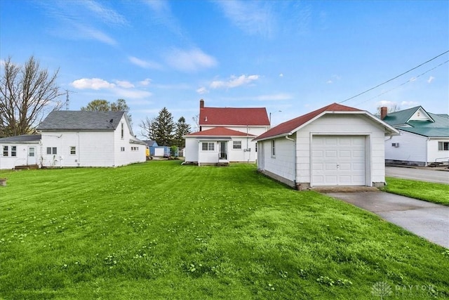 203 W Plum St, Saint Paris, OH 43072 - back of property with driveway, an outbuilding, a lawn, and a detached garage