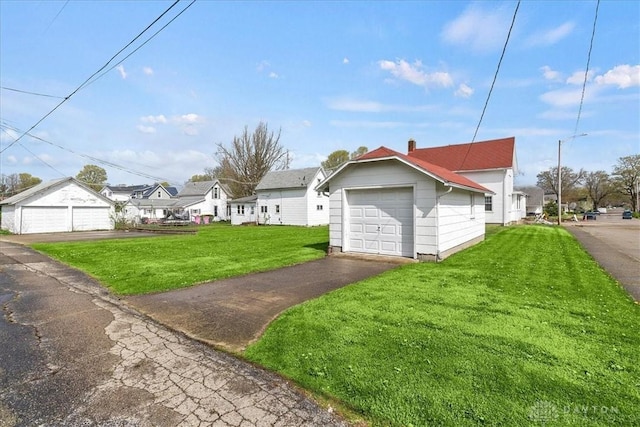 203 W Plum St, Saint Paris, OH 43072 - view of home's exterior featuring a lawn, a detached garage, a residential view, and asphalt driveway