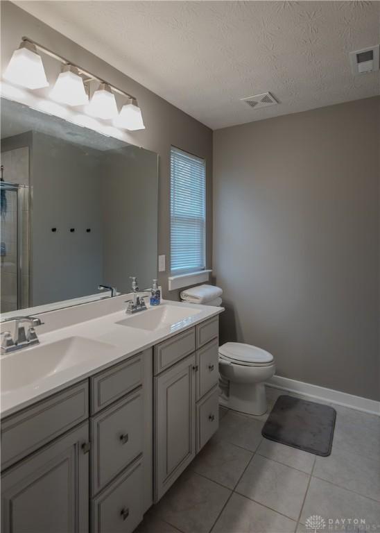 1180 Autumn Ridge Dr, Lebanon, OH 45036 - bathroom with a shower stall, a sink, double vanity, toilet, and tile patterned flooring