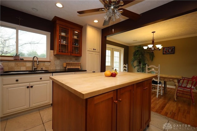115 Southlake Dr, Dayton, OH 45459 - kitchen featuring a sink, wooden counters, glass insert cabinets, ornamental molding, and hanging light fixtures