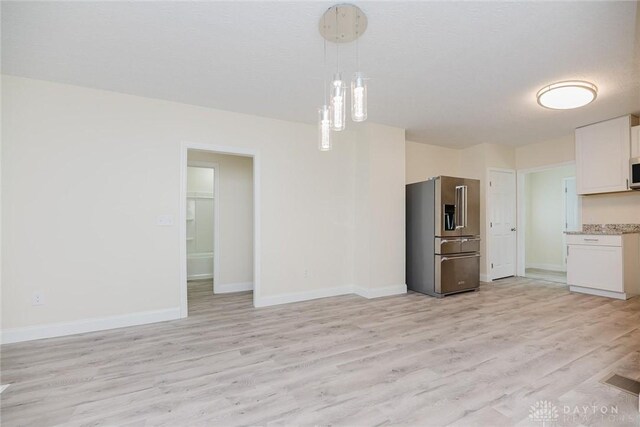 unfurnished living room with light wood finished floors and baseboards