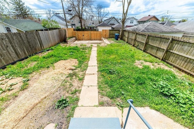 view of yard featuring a fenced backyard and a residential view