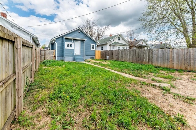 view of yard featuring a fenced backyard and entry steps
