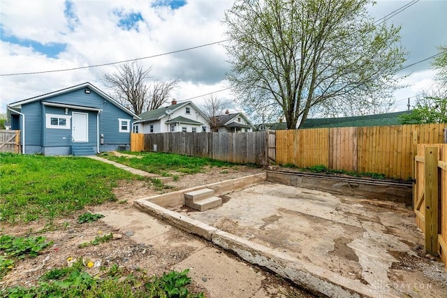 view of yard with a fenced backyard, a patio, and entry steps