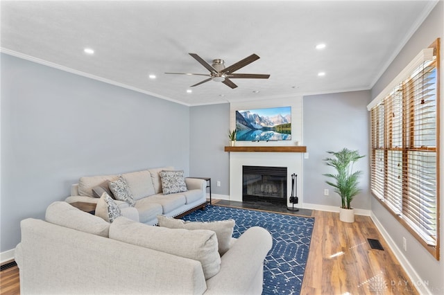 living area featuring recessed lighting, wood finished floors, visible vents, and a fireplace with flush hearth