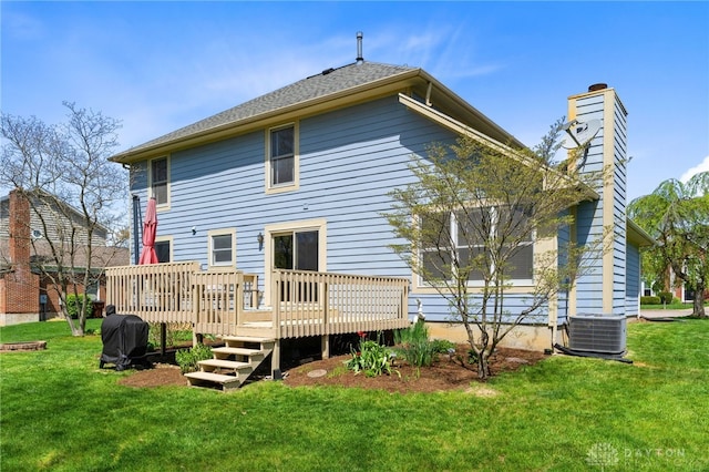 back of property with a wooden deck, a yard, cooling unit, and a chimney