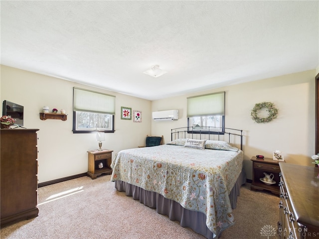 bedroom with carpet flooring, an AC wall unit, and baseboards
