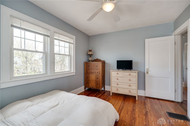 bedroom with baseboards, wood finished floors, visible vents, and a ceiling fan