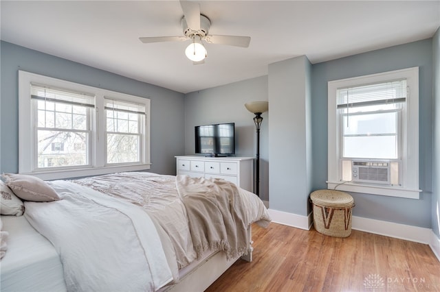 bedroom with a ceiling fan, baseboards, and light wood-style floors