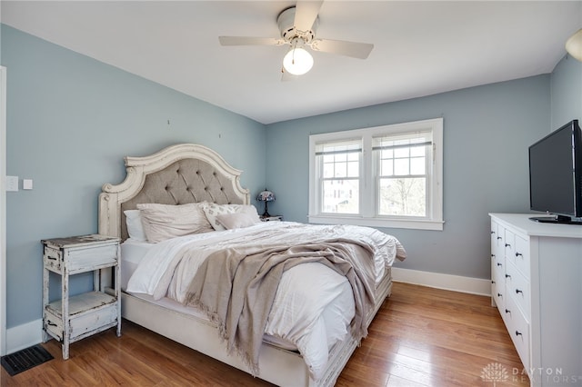 bedroom featuring wood finished floors, baseboards, and ceiling fan