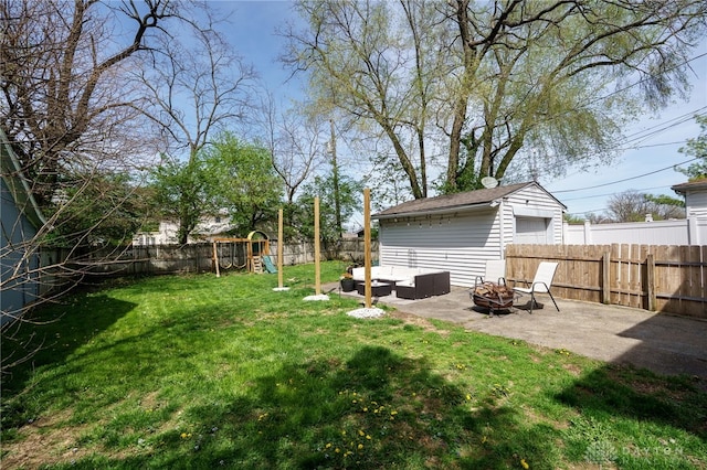 view of yard with a patio, a fenced backyard, an outdoor living space with a fire pit, and a playground