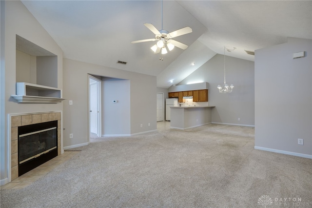 unfurnished living room with a fireplace, visible vents, light carpet, and ceiling fan with notable chandelier