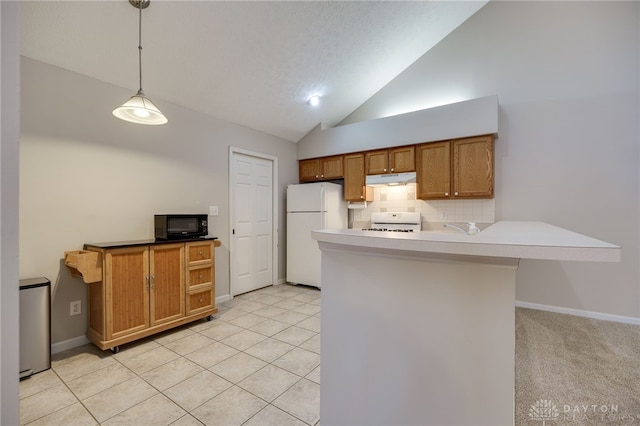 kitchen featuring freestanding refrigerator, brown cabinetry, black microwave, under cabinet range hood, and range